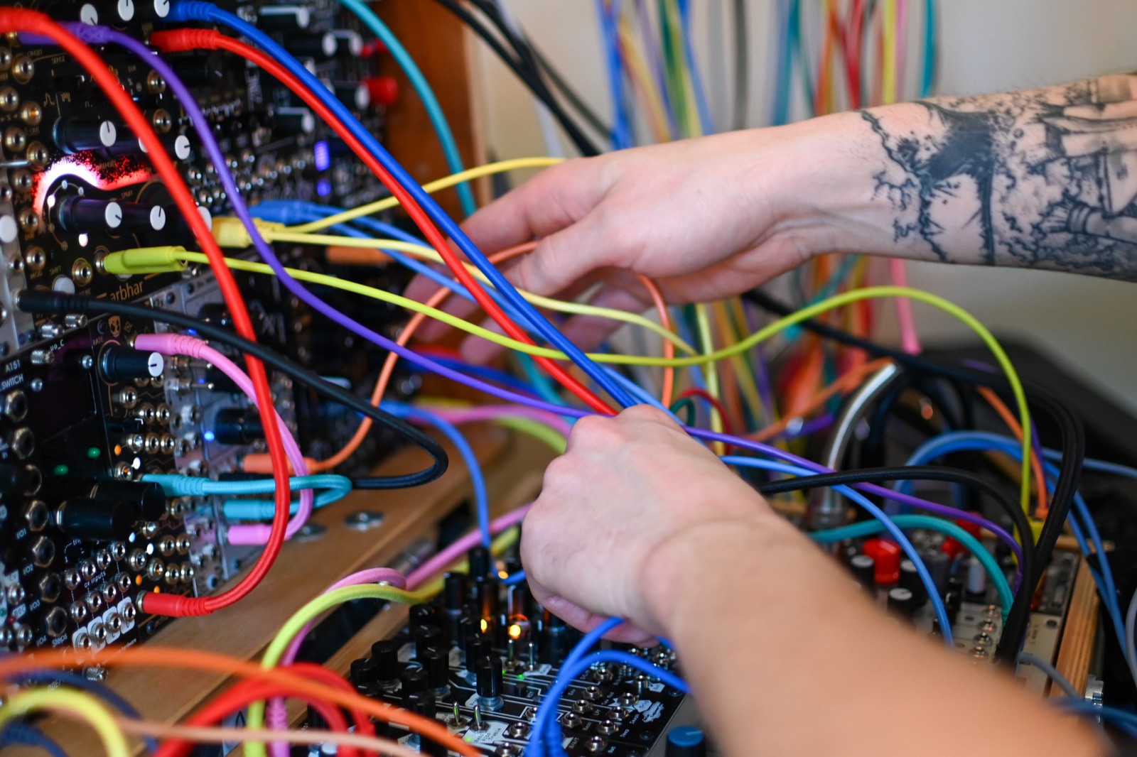 hands patching cables on the modular synthesis rig