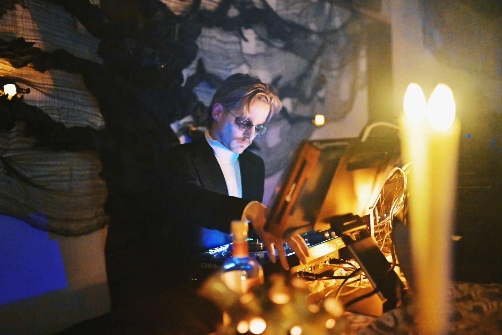 dj at the decks lit by a candelabra, fog