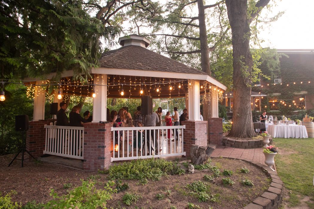 the timber gazebo lit with warm string lights at dusk